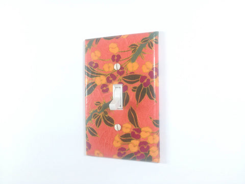 A Peachy Orange Single Toggle Switch Plate with Orangish Yellow and Plum Flowers, Green Leaves and Gold Details by The Orange Chair Studio.